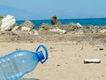 Plastikflasche und anderer Kunststoffmüll vor Meereskulisse
