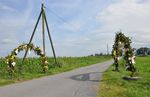 Wirtschaftsstraße in einsamer Landschaft, Girlanden als Einladung zu einem Dorffest