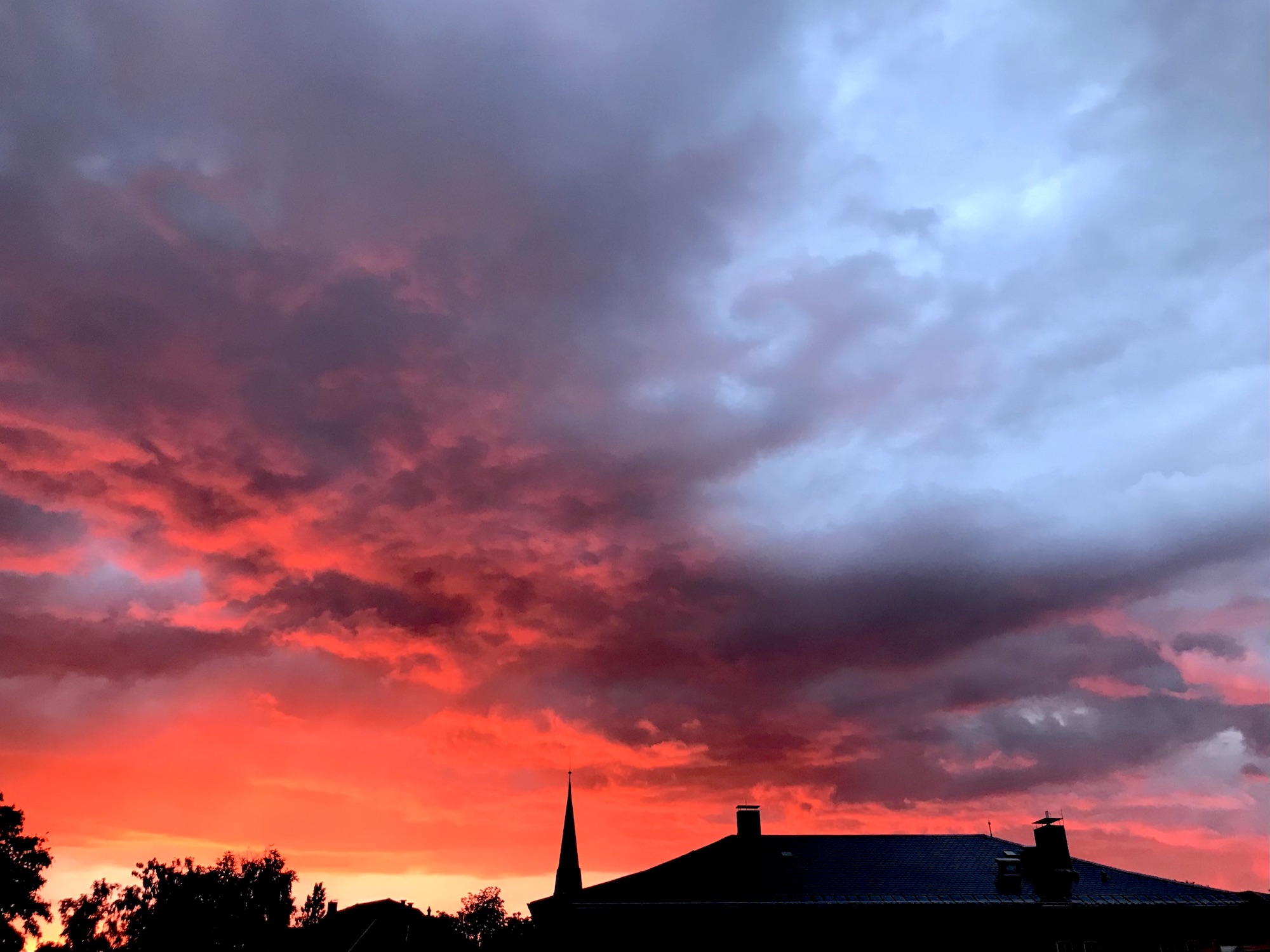 Rot-glühender Abendhimmel über Oldenburg – vermischt mit grauen Regenwolken und hellen Flecken