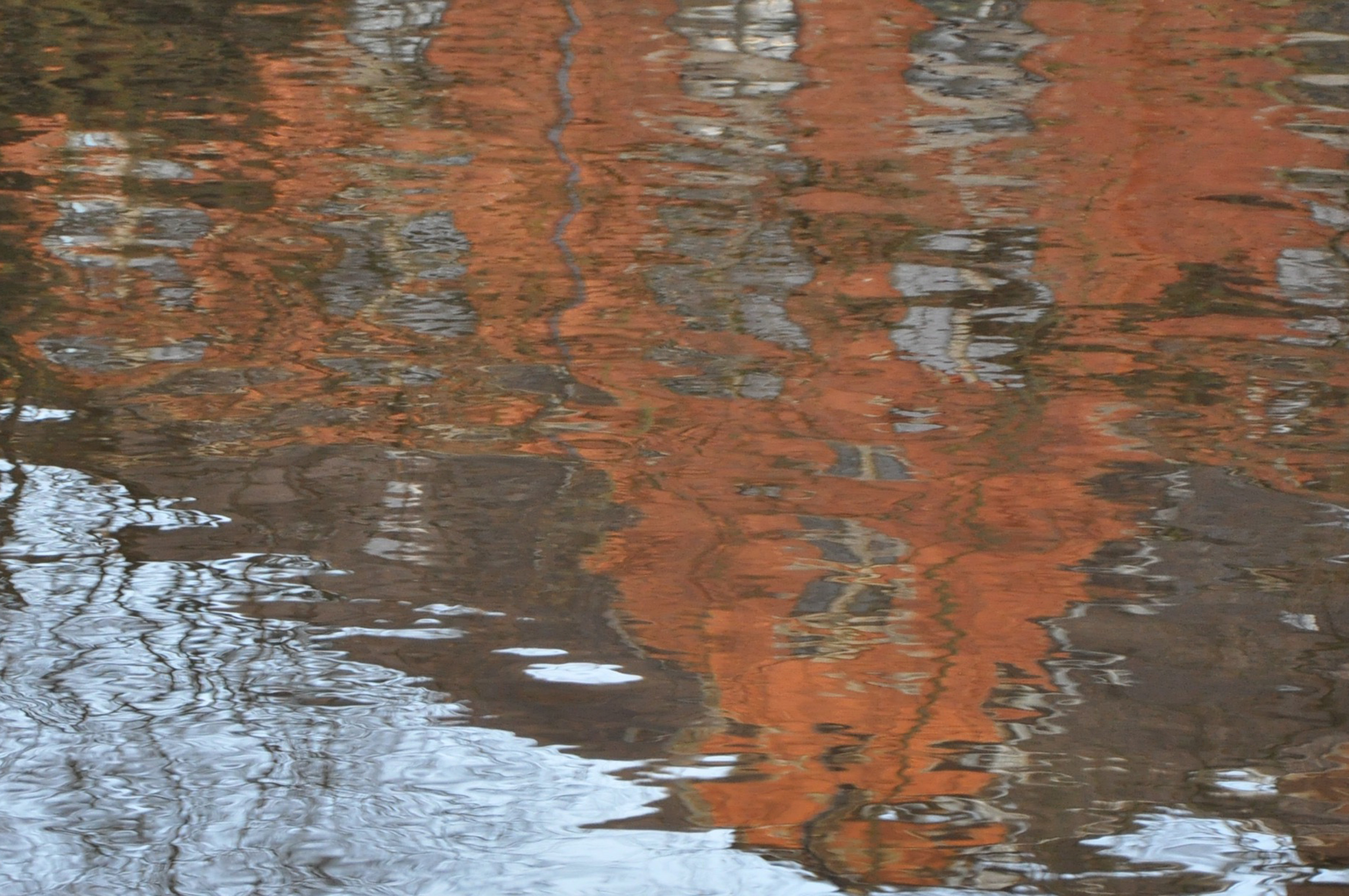 Das Rot des Oldenburger Sozialsgerichts spiegelt sich im Wasser, Oldenburg